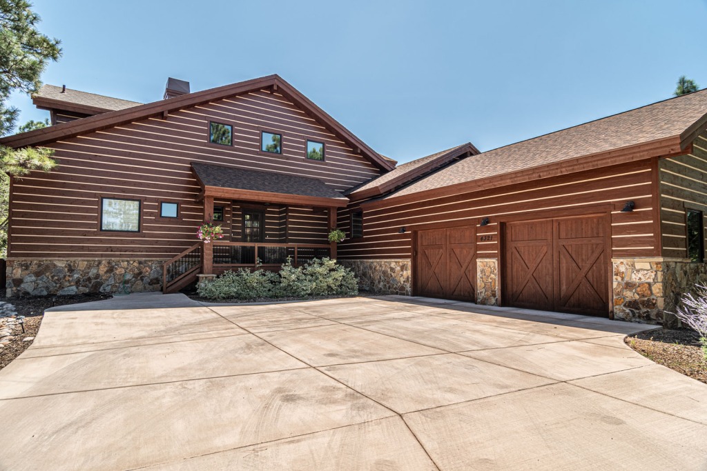 Modern log cabin with garage and driveway