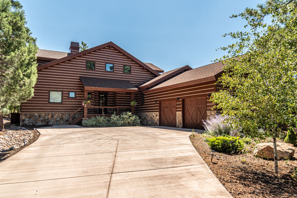 Rustic log cabin with driveway.