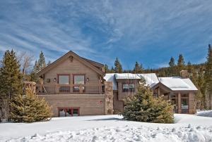 Snow-covered cabin in a forested landscape