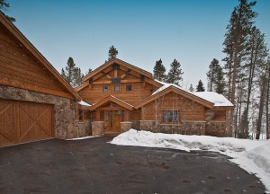 Snow-covered rustic cabin with trees