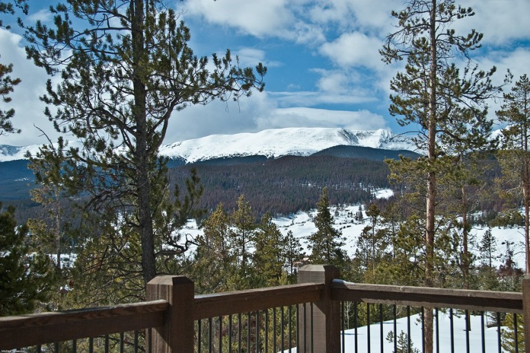 Snowy mountain view from a wooden deck