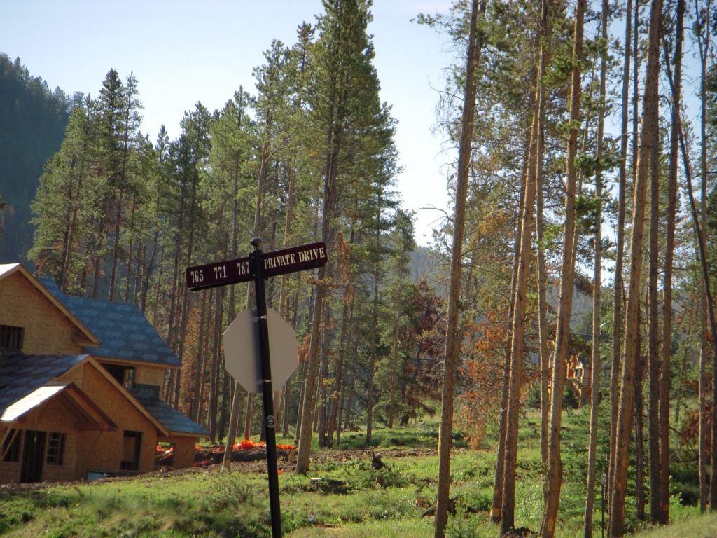 Forest road sign near a house